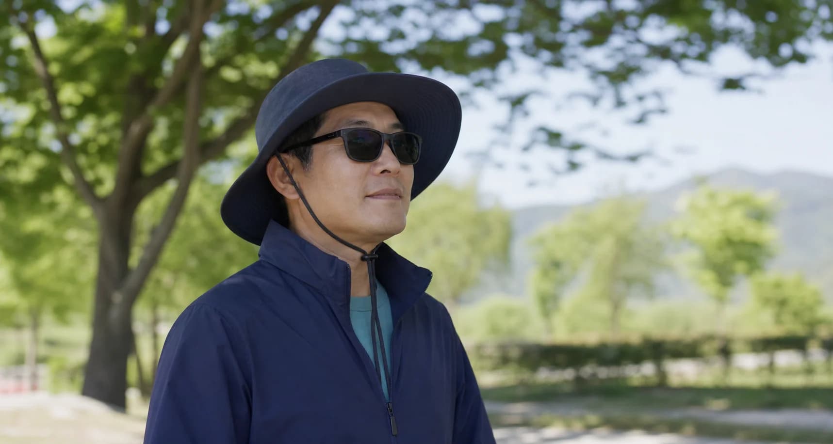 챙 넓은 모자와 자외선 차단 선글라스로 야외 활동하는 모습