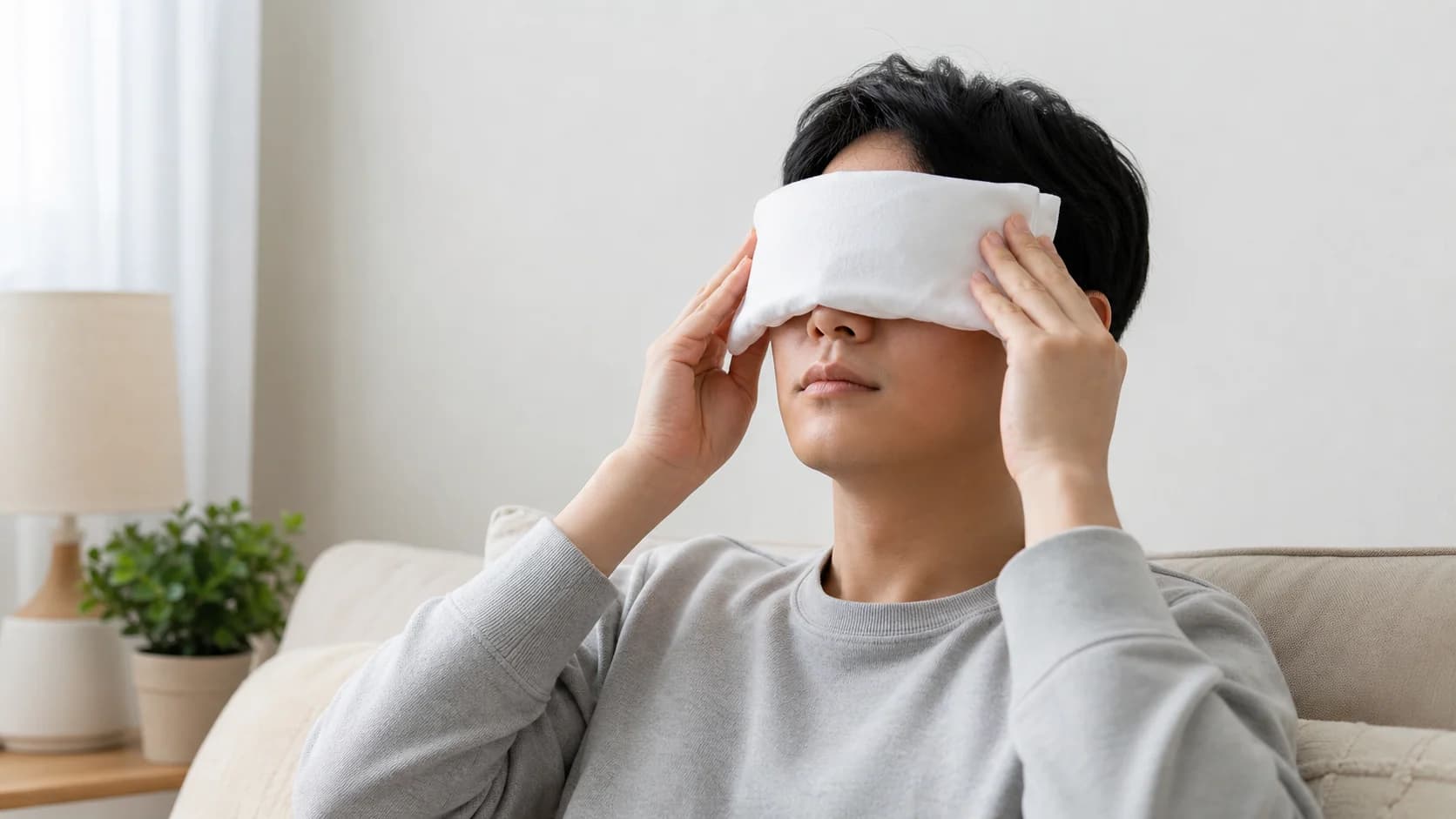 알레르기성 가려움이 있는 사람이 눈을 비비지 않고 천으로 감싼 냉찜질을 하는 모습