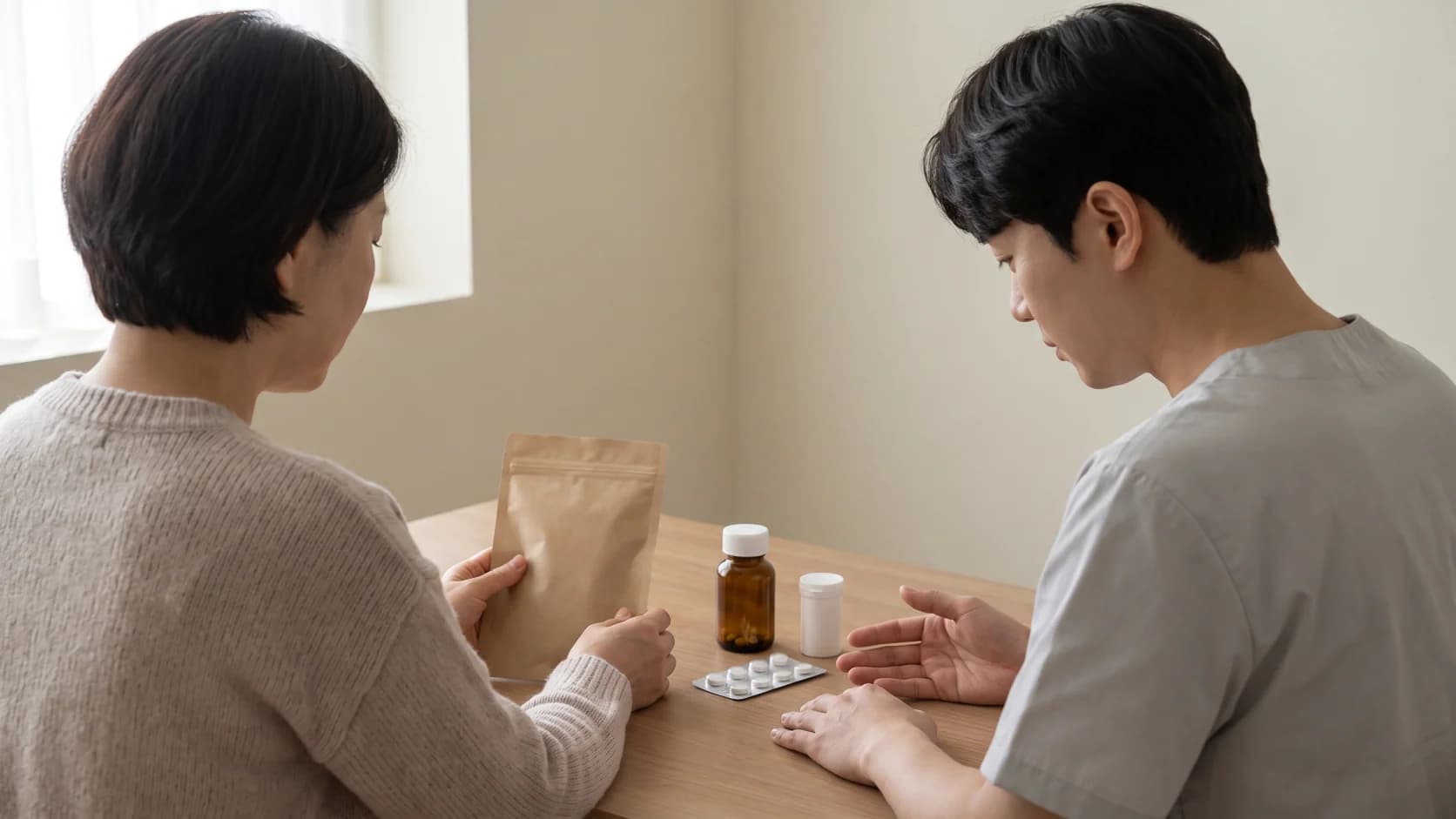 무표기 허브차 포장과 복용 중인 약 용기를 약사와 함께 확인하는 장면