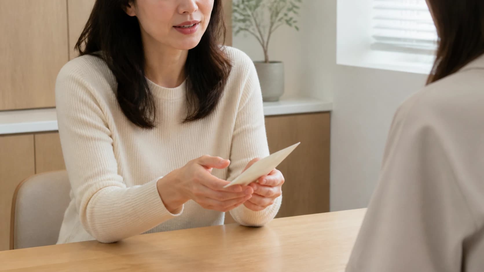 상담 테이블에서 미리 적어 온 메모를 펼쳐 놓고 이야기하는 손과 상반신